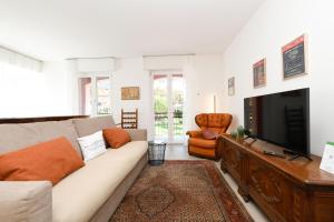 a living room with a couch and a television at MGH - Malcesine Supreme Stay in Malcesine