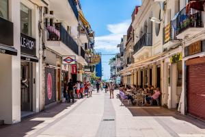 a street in a city with people walking down it at Montroig Mar in Sitges