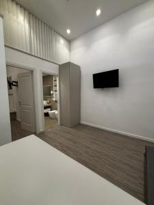 a living room with a flat screen tv on a wall at SUITE & LOFT guest house in Sabaudia