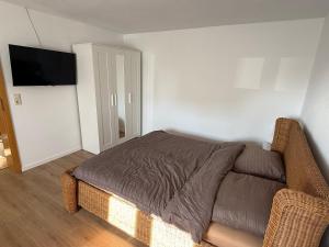a bedroom with a bed and a flat screen tv at kleines Landhaus am Park in Klein Uhyst