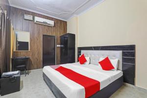 a bedroom with a large bed with red pillows at Hotel O Four Square in Lucknow
