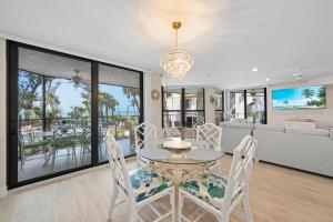 a dining room with a table and chairs and a couch at Pine Cove 104 in Sanibel