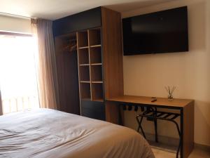 ビーニャデルマールにあるKalaMar Hotelのベッドと机とテレビのある寝室