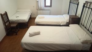 a room with three beds and a chair at Fuentestrella in Hontanas