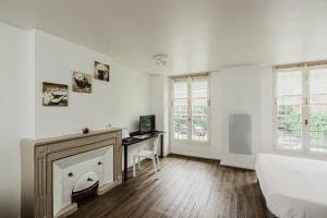 a white bedroom with a desk and a bed at Appart Hôtel Avy Baudelaire - Lyon Bellecour in Lyon