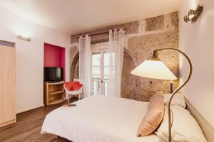 a bedroom with a white bed and a lamp at Appart Hôtel Avy Baudelaire - Lyon Bellecour in Lyon
