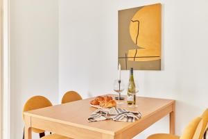 a table with a plate of food and a bottle of wine at Olivia -Einzigartiges Wohnerlebnis in Kaiserslauterns Herz in Kaiserslautern