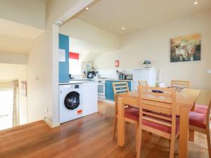 a kitchen and dining room with a table and a washing machine at The Beach House in Newquay