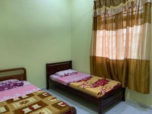 Ένα ή περισσότερα κρεβάτια σε δωμάτιο στο Faiz Homestay