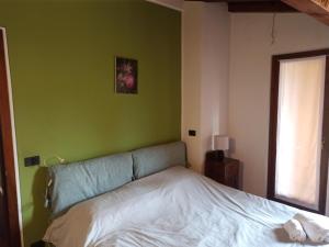 ein Schlafzimmer mit einem Bett und einer grünen Wand in der Unterkunft GuascoHome in Reggio nell'Emilia