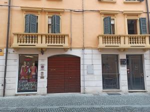 ein Gebäude mit einer braunen Tür und einem Balkon in der Unterkunft GuascoHome in Reggio nell'Emilia