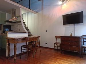ein Wohnzimmer mit einem Klavier, einem Tisch und einem TV in der Unterkunft GuascoHome in Reggio nell'Emilia + 7 Fotos