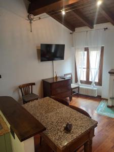 ein Wohnzimmer mit einem Tisch und einem Fernseher an der Wand in der Unterkunft GuascoHome in Reggio nell'Emilia