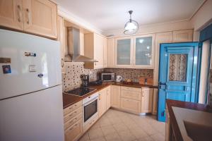 a kitchen with a white refrigerator and a sink at Villa Sapphire BeachFront Eretria in Eretria