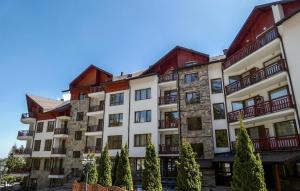 a large building with trees in front of it at Apartment for rest in Borovets in Borovets