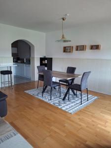 uma sala de jantar com mesa e cadeiras de madeira em Apartment Fasching em Deutsch Goritz