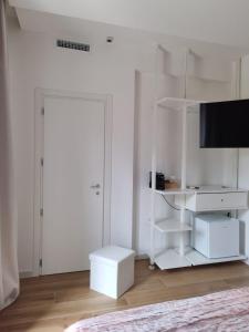 a white room with a television and a white shelf at Affittacamere La Nuvola in Chieti