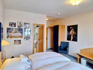 a bedroom with a bed and a desk and pictures on the wall at Retro - Art - Hotel Lünen in Lünen