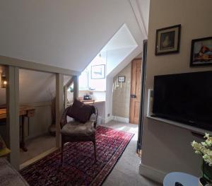 a living room with a flat screen tv and a chair at St Elmo Felixstowe in Felixstowe +10 photos