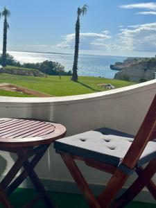a patio with a table and a chair and the ocean at Luisela Mar Algarve in Carvoeiro