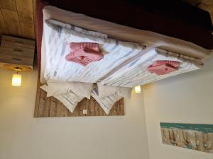 a bed with pink towels on a wall at Ferienhaus Petri Heil in Oberlangen +4 photos