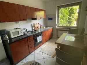 a kitchen with a microwave and a stove and a window at MAD Ferienwohnungen 1 in Dortmund