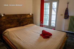 ein Bett mit einem roten Band darauf in der Unterkunft Ca' Roscia in Dolcedo