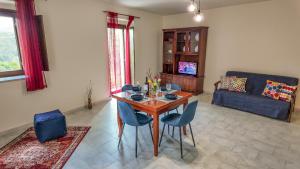 a living room with a wooden table and blue chairs at Asteria Guest&Artist House - Casa Tersìcore in Roseto Valfortore +2 photos