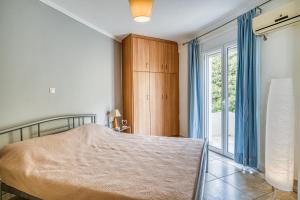 a bedroom with a bed and a large window at Komi Shoreline Blue Window in Kómi