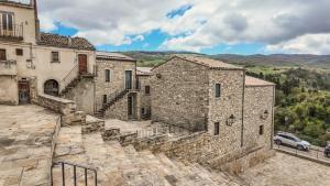 an old stone building with a car parked next to it at Asteria Guest&Artist House - Casa Tersìcore in Roseto Valfortore