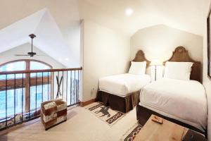 two beds in a room with a large window at Terraces 602 by Exceptional Stays in Telluride