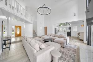 a living room with white furniture and a chandelier at Lux Family Stay with Heated Pool, Spa, Theater, Game Room in Spring