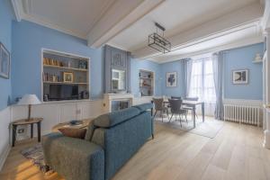 a living room with blue walls and a couch and a table at La Belle Epoque in Bayeux