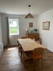 a dining room with a wooden table and chairs at Maison des Vendanges in Cesset