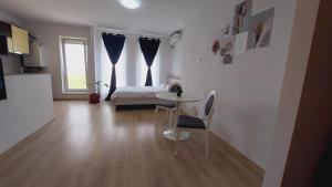 a room with a table and chairs and a bed at Garsoniera Studio in Constanţa
