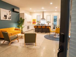 a living room and kitchen with a yellow couch and chairs at King Suite | North Shore | Gigabit Internet in Chattanooga