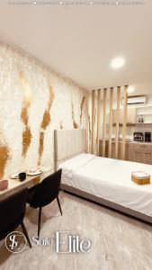 巴耶杜帕尔Suite Elite Valledupar的卧室里有一张白色的大床和一张桌子