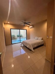 a bedroom with a bed and a ceiling fan at Chalet con 3 habitaciones y alberca privada in Mérida +13 photos