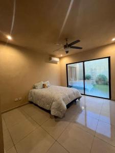 ein Schlafzimmer mit einem Bett und einem Deckenventilator in der Unterkunft casa de una planta con alberca in Mérida