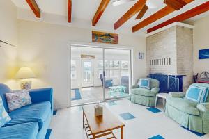 Una sala de estar con un sofá azul y dos sillas. en Bayside Bungalow, en Dauphin Island