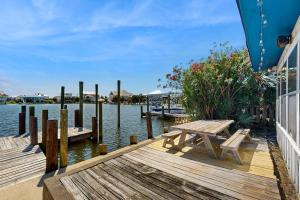 muelle de madera con mesa de picnic en el agua en Bayside Bungalow, en Dauphin Island