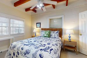 Un dormitorio con una cama azul y blanca con dos lámparas. en Bayside Bungalow, en Dauphin Island