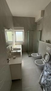 a bathroom with two toilets and a sink and a shower at K&M apartment in Polisi i Vogël