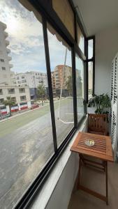 a window with a wooden table and a view of a street at K&M apartment in Polisi i Vogël