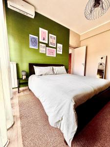 a bedroom with a large bed with a green wall at Casa Nico in Rome