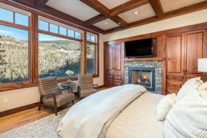 a bedroom with a bed and a fireplace and a tv at Two Trails by Exceptional Stays in Telluride