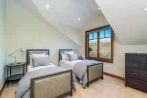 a attic bedroom with two beds and a window at Two Trails by Exceptional Stays in Telluride