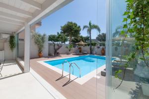 an indoor swimming pool with a view of a house at Dimora Nesea in Cozze