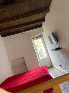 コルテにあるSottu à a Citadellaのベッドルーム1室(赤いベッド1台、窓付)