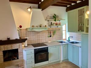 a kitchen with blue cabinets and a stove top oven at Agriturismo Santa Maria in Pienza